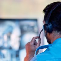 Back view guy talking headphone